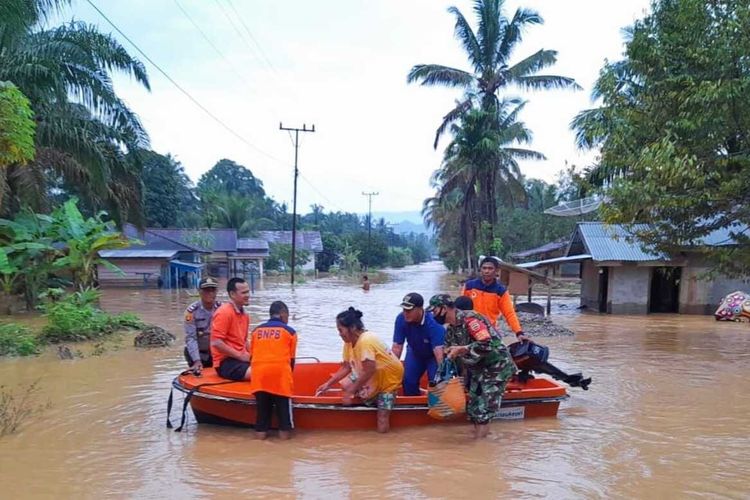 Petugas mengevakuasi warga yang terdampak banjir di Desa Rambah Tengah Hulu, Kecamatan Rambah, Kabupaten Rokan Hulu, Riau, Sabtu (25/12/2021).