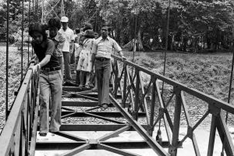 Dengan hati-hati, sejumlah pengunjung berjalan melewati jembatan gantung Kebun Raya Bogor. Situasi ini termuat di Kompas edisi Selasa, 19 April 1977.