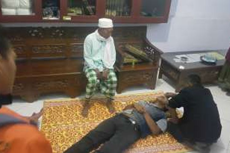 Foto : Seorang ustadz sementara merukyah pria yang tiba-tiba pingsan didalam masjid Agung Ponorogo, Jumat ( 18 / 11 / 2016) malam. 