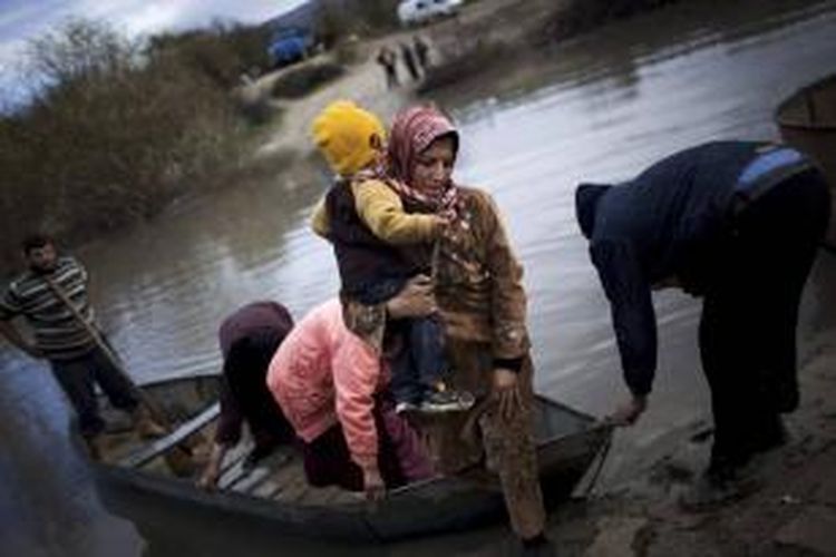 FILE - Pengungsi Suriah menyeberang dari Suriah ke Turki melalui Sungai Orontes, dekat Desa Hacipasa, Turki, 8 Desember 2012. Foto ini salah satu dari 20 foto karya fotografer AP yang memenangkan Pulitzer Prize 2013 kategori foto Breaking News.