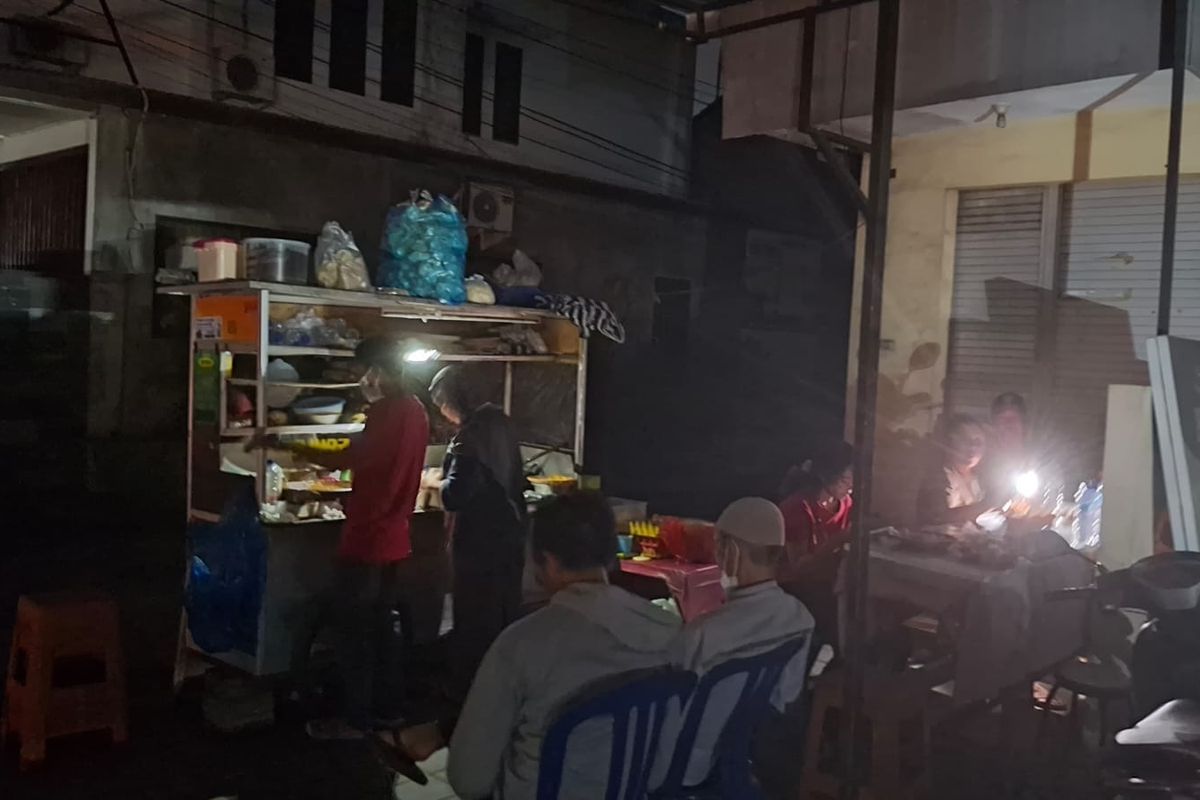 Pedagang di Bali menggunakan senter ponsel dan lilin untuk penerangan karena listrik padam, Jumat (2/5/2025)