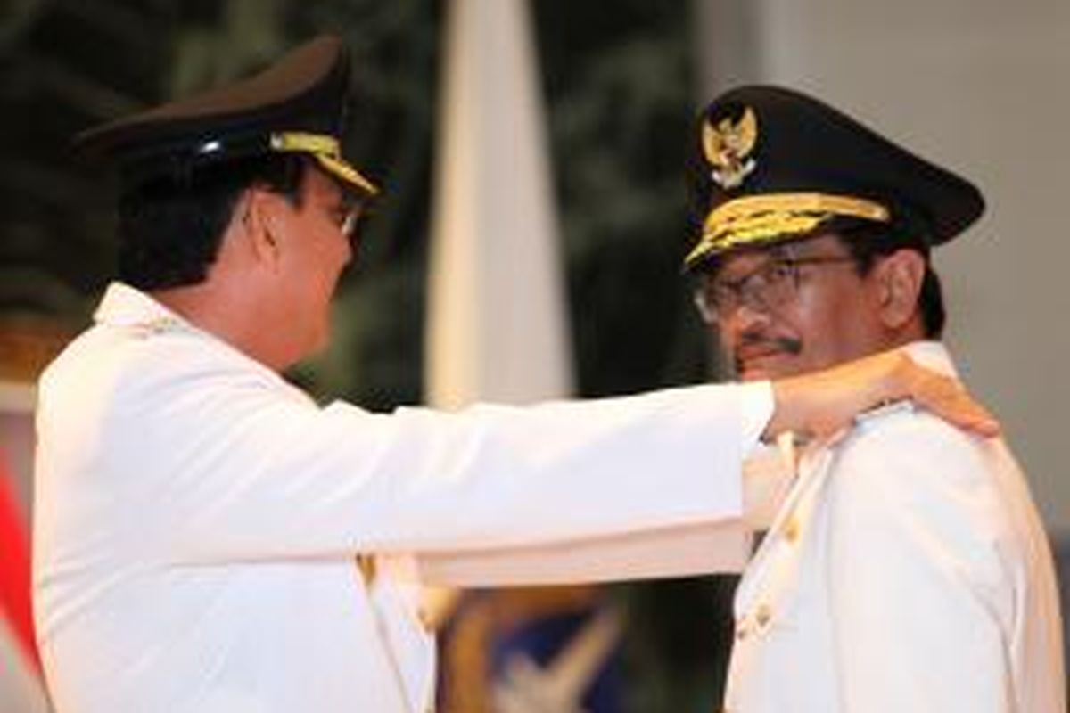 Gubernur DKI Jakarta, Basuki Tjahja Purnama (kiri)memberikan tanda pangkat kepada Wakil Gubernur, Djarot Saiful Hidayat di Balai Kota Jakarta, Rabu (17/12). Hadir dalam acara tersebut, Presien Indonesia kelima, Megawati Soekarno Putri dan istri Gubernur DKI, Veronica Tjahja Purnama, dan Istri Wakil Gubernur, Happy Farida. Kompas/Lucky Pransiska (UKI) 17-12-2014