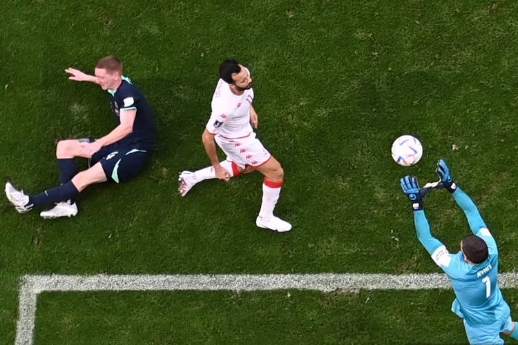 Kiper Australia Mathew Ryan (kanan) melakukan penyelamatan di samping penyerang Tunisia, Taha Khenissi, dan bek Australia, Kye Rowles (kiri), pada pertandingan Grup D Piala Dunia 2022 Qatar antara Tunisia vs Australia di Stadion Al-Janoub di Al-Wakrah, selatan Doha pada Sabtu 26 November 2022.