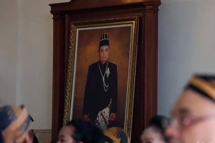 Tamu undangan dan kerabat dengan latar belakang foto Raja Keraton Surakarta Sampeyan Ndalem Ingkang Sinuhun Kanjeng Susuhunan Paku Buwono XIII saat pergelaran tradisi tingalan dalem jumenengan di Keraton Surakarta, Kota Surakarta, Jawa Tengah, Kamis (16/2/2023).