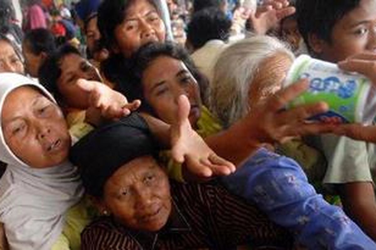 Sejumlah pengungsi berebut untuk mendapatkan makanan ringan di posko pengungsian Stadion Maguwoharjo, Sleman, Yogyakarta, Sabtu (6/11/2010).