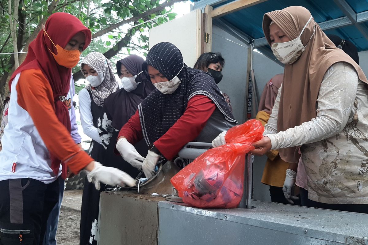 Ibu-ibu anggota kelompok Bank Sampah Telok Lemak, mendaur ulang masker bekas menjadi BBM, di Pantai Bangsring, Desa Bangsring, Kecamatan Wongsorejo, Kabupaten Banyuwangi, Jawa Timur, Kamis (27/1/2022).
