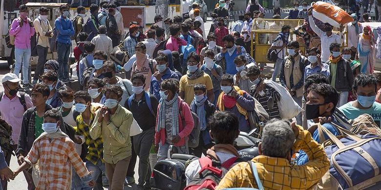 Buruh migran menunggu bus di sebuah terminal angkutan umum selama karantina wilayah (lockdown) di New Delhi, India, Minggu (29/3/2020). Pemerintah India pada 24 Maret lalu mulai memberlakukan lockdown selama 21 hari di seluruh wilayah negara itu dalam upaya mengendalikan penyebaran COVID-19.