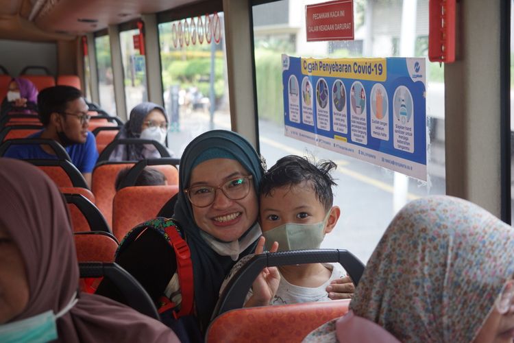 Warga Pamulang, Tangerang Selatan, Adel Dachlan dan anaknya, Arsaka, berpose di dalam bus wisata Transjakarta atau bus Jakarta Explorer, Minggu (23/4/2023).