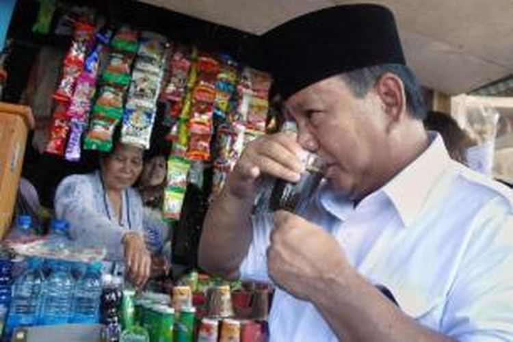 Calon presiden Prabowo Subianto minum kopi di warung saat berkampanye di Cililin, Bandung, Jawa Barat, Jumat (13/6/2014).