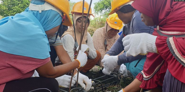 Hairunisa (baju putih) bersama sejumlah Ibu di desa Beka, Marawola, Kabupaten Sigi, Sulawesi Tengah mempraktekkan cara mengikat batang-batang besi yang digunakan untuk kebutuhan tiang bangunan rumah, 7 Desember 2019. 