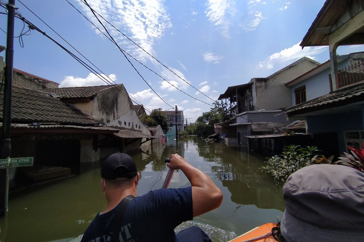 Banjir yang masih menggenangi wilayah RW 011, Kelurahan Periuk, Kecamatan Periuk, Kota Tangerang, Banten sampai Senin (22/2/2021) siang sejak Sabtu (20/2/2021). Banjir di wilayah tersebut akibat luapan Kali Ciracap dan hujan dengan intensitas tinggi pada Sabtu pekan lalu.