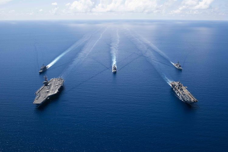 (FILE) This US Navy photo obtained October 7, 2019 shows the aircraft carrier USS Ronald Reagan (CVN 76)(L), and the amphibious assault ship USS Boxer (LHD 6) and ships from the Ronald Reagan Carrier Strike Group and the Boxer Amphibious Ready Group underway in formation while conducting security and stability operations in the US 7th Fleet area of operations on October 6, 2019 in the South China Sea. US 7th Fleet is the largest numbered fleet in the world, and the US Navy has operated in the Indo-Pacific region for more than 70 years, providing credible, ready forces to help preserve peace and prevent conflict. (Photo by Erwin Jacob V. MICIANO / Navy Office of Information / AFP) 