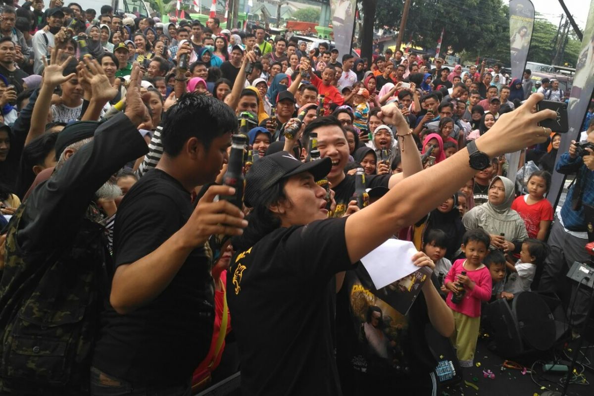 Aktor Vino G Bastian berfoto bersama pengunjung saat menghadiri acara car free day di kawasan Cijantung, Jakarta Timur, Minggu (26/8/2018) pagi.