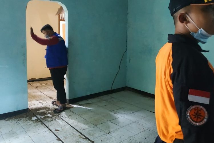Dua petugas mengecek rumah rusak akibat bencana tanah bergerak di Desa Neglasari, Kecamatan Cibadak, Sukabumi, Jawa Barat, Jumat (11/12/2020).