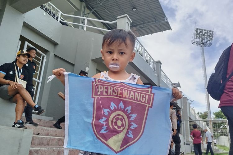 Gala memegang bendera Persewangi untuk mendukung tim tersebut bertanding melawan Persebo Muda Bondowoso di Stadion Diponegoro, Rabu (8/1/2025). 