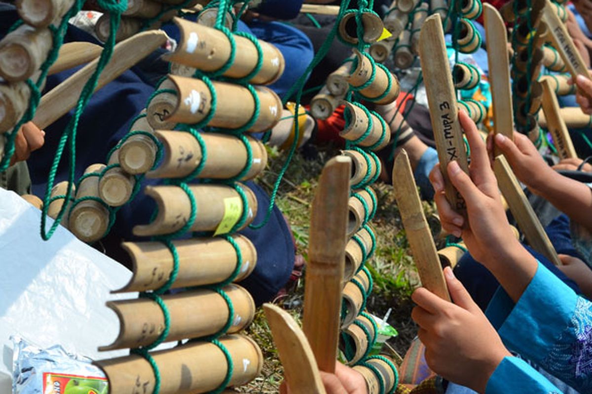 Sejumlah pelajar memainkan alat musik tradisional Calung renteng pada acara Preanger Tourism Fair 2018 di Karangresik, Kota Tasikmalaya, Jawa Barat, Minggu (14/10/2018). Pertunjukan yang dikemas lewat kolaborasi antara calung renteng, angklung, perkusi dan alat musik modern itu dimainkan oleh 1.093 pelajar dari 15 sekolah bertujuan untuk melestarikan calung renteng agar lebih dikenal oleh generasi muda.  