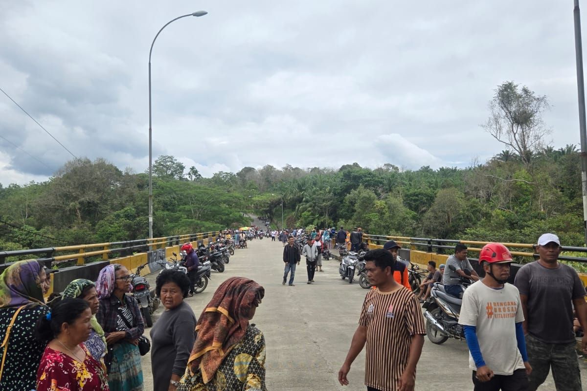Masyarakat memadati jembatan Lau Ligung di Kecamatan STM Hilir, Kabupaten Deli Serdang, Sumatera Utara, Rabu (26/2/2025). Ditempat tersebut Kades Liang Pematang hilang misterius.