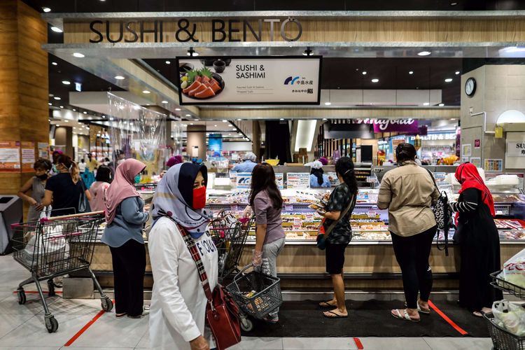 Pembeli menggunakan masker saat antre dengan menjaga jarak untuk melakukan pembayaran dari balik plastik pembatas di supermarket AEON Mal Serpong, Tangerang, Banten, Selasa (26/5/2020). Pemerintah Indonesia bersiap menerapkan tatanan baru (new normal) dalam waktu dekat. Salah satunya dengan mulai membuka pusat perbelanjaan secara bertahap di bulan Juni mendatang.