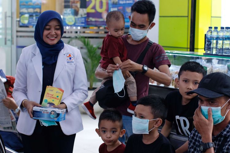 A file photo of a health worker gives out masks in Gambir Station, Central Jakarta dated January 31, 2020.  