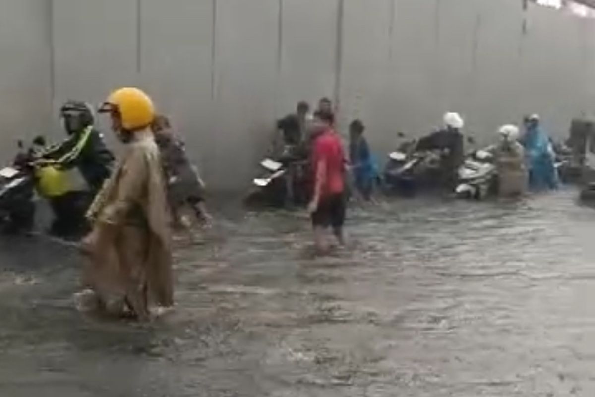 Banjir setinggi lutut orang dewasa merendam Jalan Layang Waru pada Selasa (24/12/2024) sore membuat pengendara mendorong motornya yang mogok