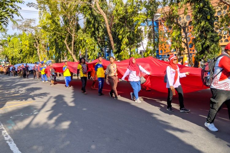 Suasana kirab bendera raksasa ke Gunung Klotok, Kota Kediri, Jawa Timur,  Jumat (16/8/2024), dalam merayakan HUT RI Ke-79.