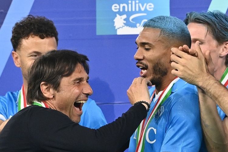 Antonio Conte berselebrasi dengan Juan Jesus dalam seremoni juara Liga Italia usai pertandingan sepak bola Serie A Liga Italia antara Napoli vs Cagliari di stadion Diego Armando Maradona di Naples pada 23 Mei 2025. (Photo by Isabella BONOTTO / AFP)