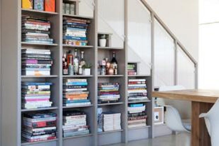 Dengan rak di bawah tangga ini, Anda tidak hanya bisa meletakkan buku-buku, tetapi juga menambahkan hiasan.