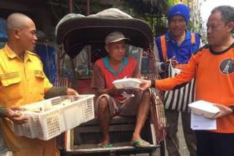 Juru parkir Malioboro, Yogyakarta, Jumat (11/3/2016), membagikan nasi bungkus kepada tukang becak, penyapu jalan dan masyarakat, sebelum salat Jumat dan memohon didoakan agar lahan parkir tidak dipindahkan. 
