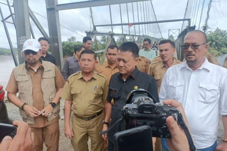 Penjabat (Pj) Bupati Kampar Hambali saat meninjau kondisi jembatan gantung dan abrasi Sungai Kampar, di Desa Gobah, Kecamatan Tambang, Kampar, Riau, Selasa (16/1/2024). 