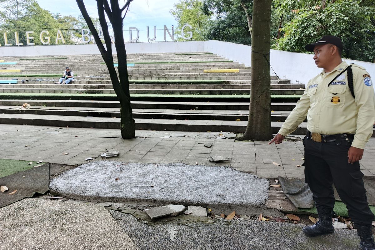 Petugas keamanan menunjukkan lokasi area Taman Tegalega, Kota Bandung, Jawa Barat yang sudah diperbaiki setelah rusak akibat aktivitas pencarian koin digital pada pekan lalu, Senin (13/1/2025).