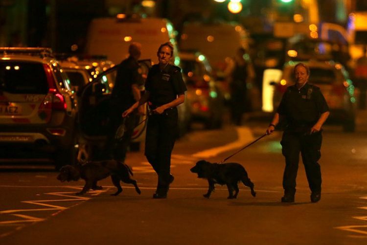 Petugas polisi membawa anjing pelacak di wilayah Finsbury Park, di London utara, setelah sebuah van menabraki sejumlah pejalan kaki pada Senin dinihari (19/6/2017).  
