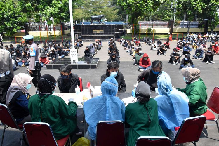 Ratusan pengunjuk rasa dikumpulkan di tengah lapangan untuk menjalani rapid test oleh petugas kesehatan di Mapolrestabes Bandung, Kamis (8/10/2020). Sebanyak 209 pemuda yang diamankan usai kericuhan pada demonstrasi menolak Undang-undang Cipta Kerja, dari ratusan pemuda itu, 13 orang reaktif.