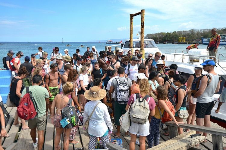 Wisatawan mancanegara tiba dengan kapal cepat di Pelabuhan Padangbai, Kabupaten Karangasem, Bali, Selasa (3/10/2017). Status Gunung Agung yang mengalami peningkatan dari level III (Siaga) menjadi level IV (Awas) tak berdampak signifikan terhadap kunjungan sejumlah destinasi wisata di Bali yang tetap ramai pengunjung.