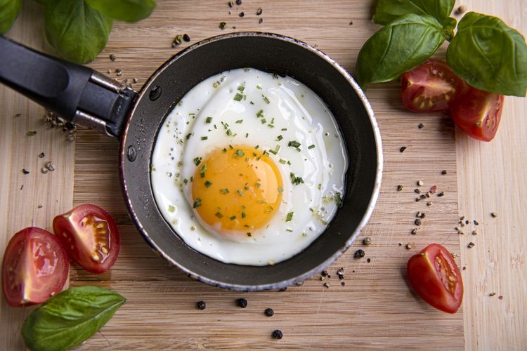 Ilustrasi telur ceplok atau telur mata sapi di wajan teflon. 