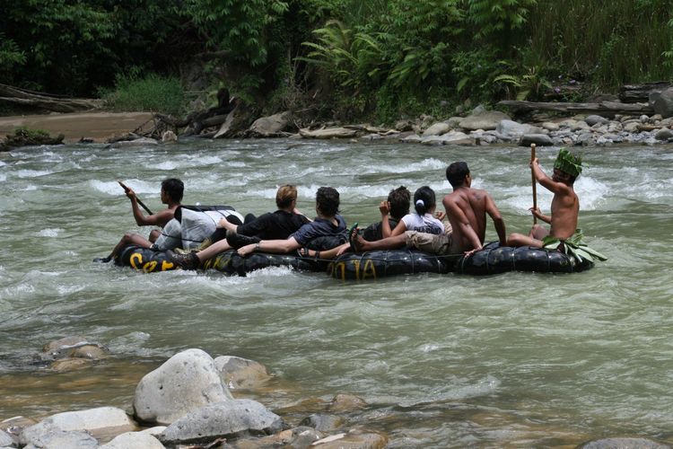 Pemandangan menakjubkan Bukit Lawang dengan sungai yang jernih mengalir di tengah hutan tropis yang lebat, menawarkan kedamaian dan keindahan alam.