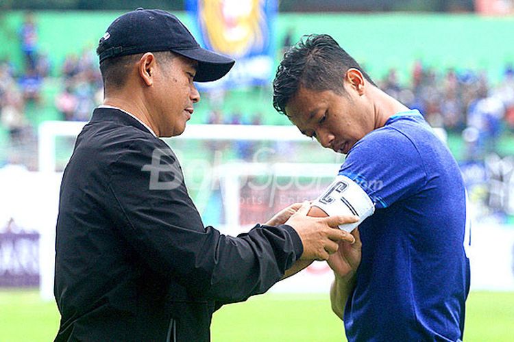 Pelatih Arema FC, Joko Susilo (kiri), membantu memasang ban kapten ke lengan Dendi Santoso dalam laga ujicoba melawan PSIS Semarang di Stadion Gajayana Malang, Jawa Timur, Kamis (04/01/2017) sore.