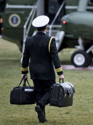 Seorang ajudan militer membawa koper nuclear football yang berisi kode rahasia dan prosedur peluncuran serangan nuklir oleh presiden Amerika Serikat, untuk diangkut ke helikopter Marine One di South Lawn, Gedung Putih, 3 Februari 2017.