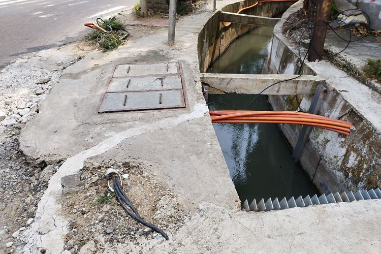 Sejumlah kabel fiber optik tampak mencuat dan semrawut di trotoar perempatan Jalan Gunung Sahari, Kemayoran, Jakarta Pusat, pada Senin (20/3/2023). (KOMPAS.com/XENA OLIVIA)