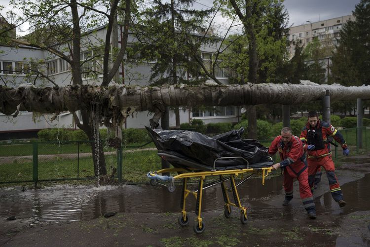 Petugas darurat mengevakuasi jenazah seorang pria yang tewas dalam pemboman Rusia di Kharkiv, Ukraina, Rabu, 27 April 2022. 