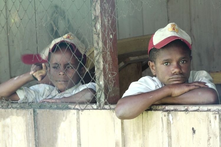 Dua orang anak menggunakan seragam, ketika memandang keluar dari jendela di SD YPPK kelas jauh Kampung Akarenda, Distrik Yaffi, Kabupaten Keerom, Papua belum lama ini. SD YPPK kelas jauh di Akarenda menjadi sekolah bagi anak-anak dari Kampung Nindifae di PNG.