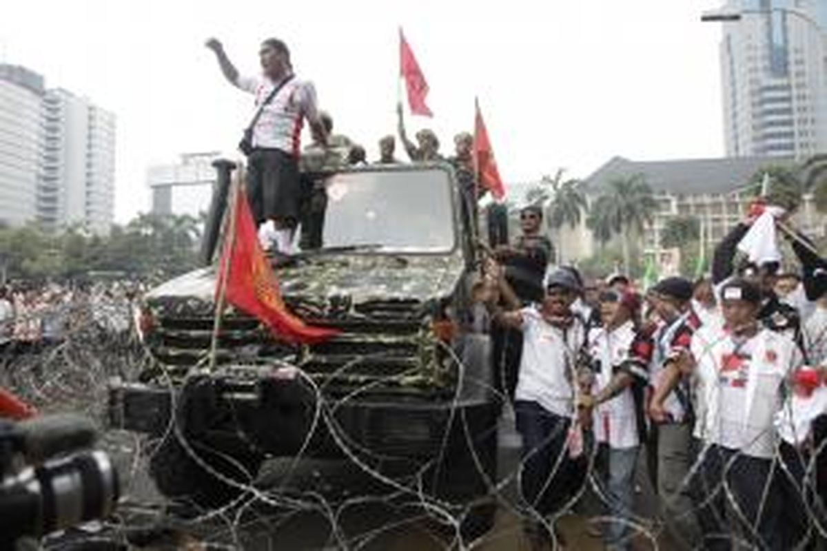 Massa pendukung pasangan Prabowo Subianto-Hatta Rajasa berusaha menerobos kawat berduri yang terpasang untuk pengamanan sidang di Mahkamah Konsistusi di Jalan Medan Merdeka Barat, Jakarta, Kamis (21/8/2014). Hari ini Mahkamah Konsistusi akan memberikan keputusan atas kasus perselisihan hasil pemilihan umum (PHPU) presiden dan wakil presiden 2014. KOMPAS IMAGES/RODERICK ADRIAN MOZES 