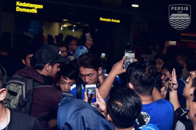 Pemain Persib Bandung Oh Ink Kyun saat mendapat pelukan dari bobotoh saat tiba di Bandara Husein Sastranegara, Jalan Padjadjaran, Kamis (25/10/2018).