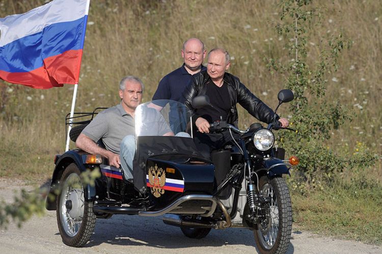 Presiden Rusia Vladimir Putin ketika mengendarai motor Ural bersama dua pemimpin Crimea pada Agustus 2019. Baik Putin dan Presiden RI Joko Widodo (Jokowi) sama-sama pernah mendapat komplain karena dianggap melanggar lalu lintas.