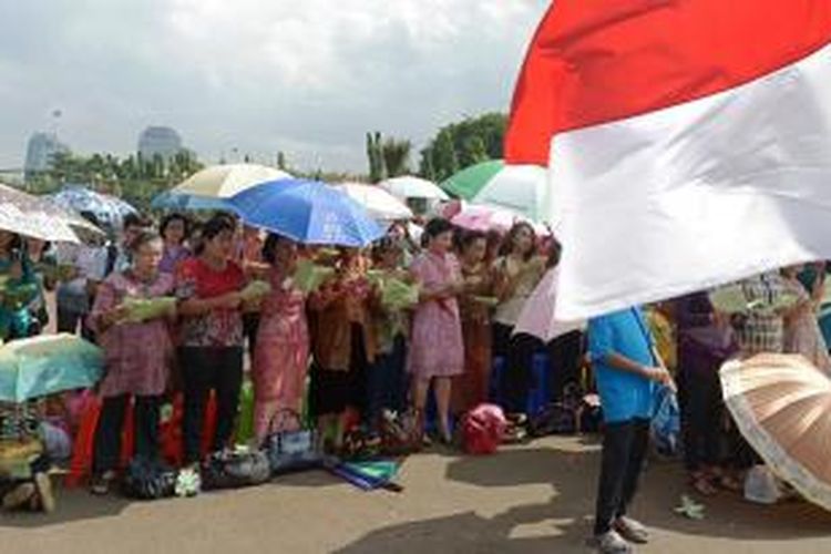 Meski terik dan sempat turun hujan, jemaat Gereja Yasmin dan HKBP Filadelfia tetap melaksanakan ibadah di seberang Istana Merdeka, Jakarta, Rabu (25/12/2013). Mereka memprotes karena kasus pembangunan gereja yang tak kunjung selesai.