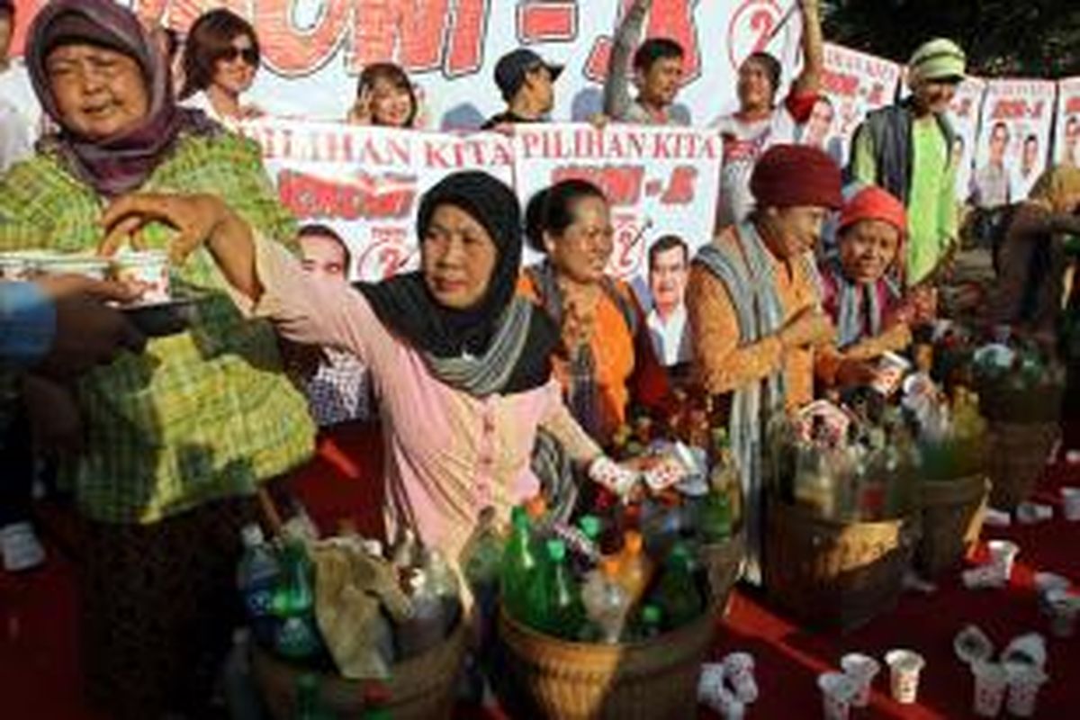 Penjual jamu gendong memberikan jamu gratis kepada warga yang sedang menikmati car free day di sekitar bundaran HI Jakarta Pusat, Minggu (8/6/2014). Penjual jamu ini memberikan jamu gratis sebagai ungkapan dukungannya kepada pasangan Jokowi-JK.