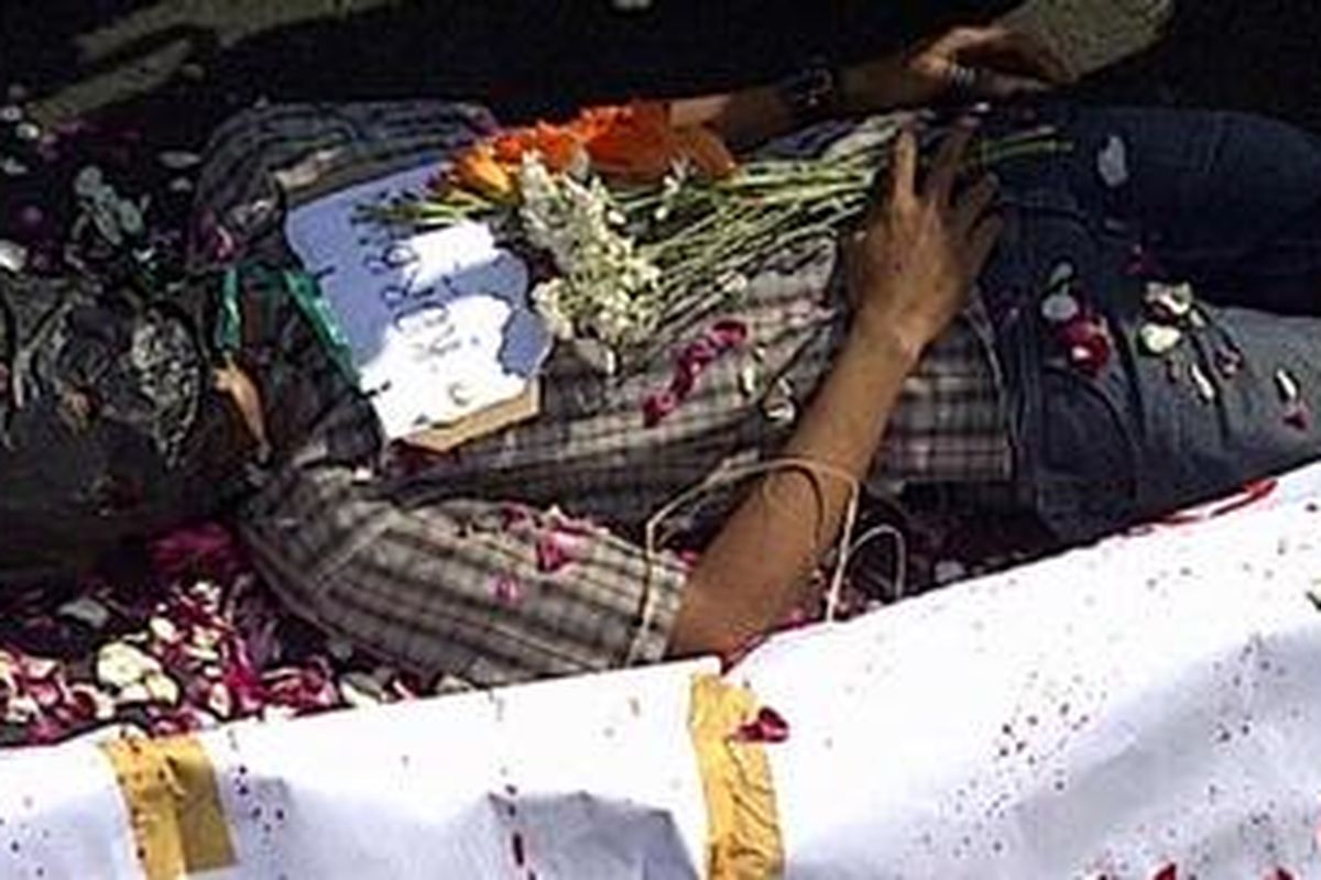 Seorang peserta aksi berbaring di samping keranda untuk menggambarkan ketiadaan perlindungan dari pemerintah terhadap TKI, dalam unjuk rasa solidaritas untuk Ruyati di bundaran Undip, Rabu (22/6/2011).