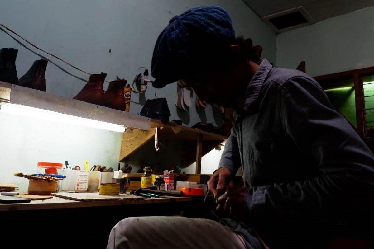 Pemilik Onderhoud Handmade, Rizky Afnan Penggalih, tengah mengerjakan sepatu.