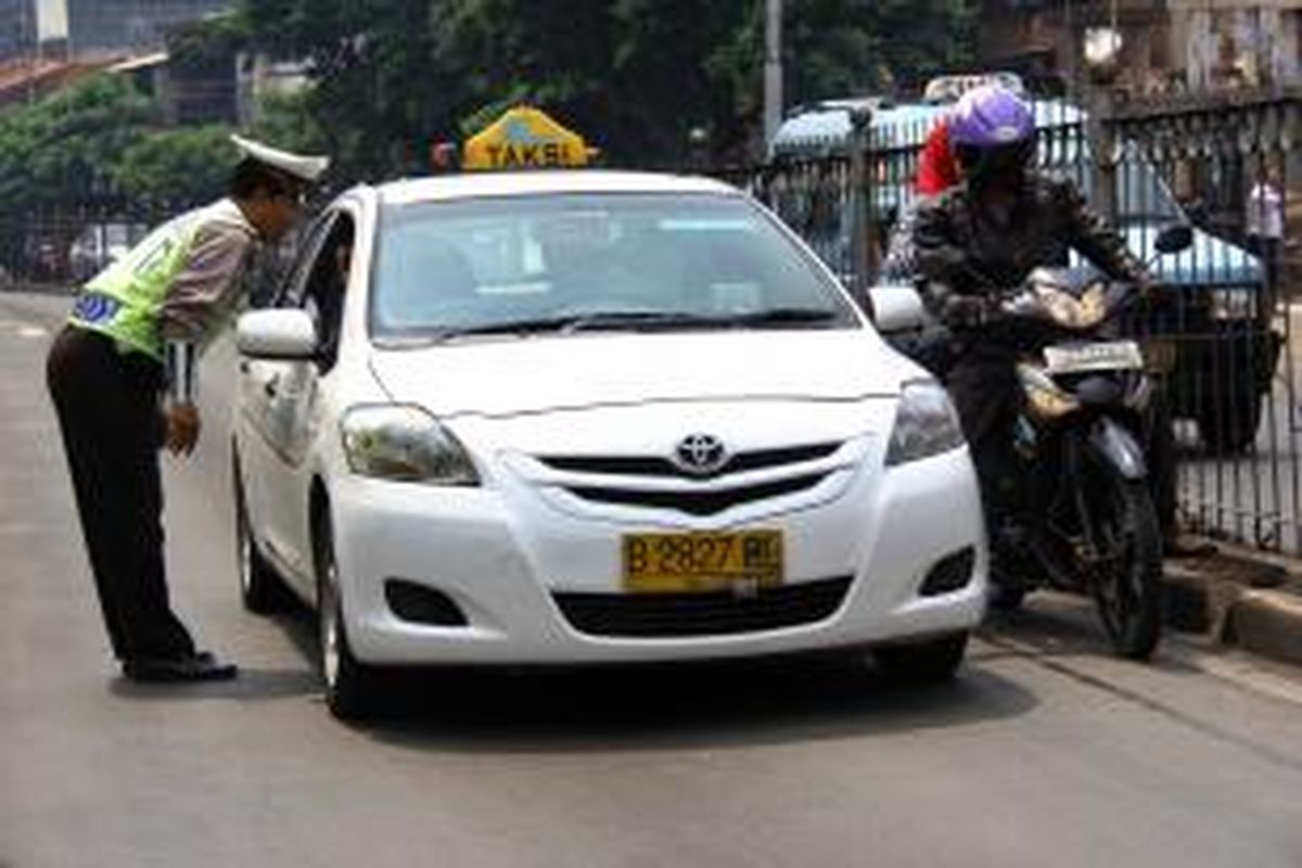 Pengendara nekat menerobos jalur Busway di Kawasan Jalan Jatinegara Barat Raya, terjaring razia oleh petugas kepolisian Polres Jakarta Timur, Kamis (15/11/2012). Beberapa kendaraan yang terjaring langsung ditindak oleh petugas dengan memberikan surat tilang. BERITA KOTA/ANGGA BN 