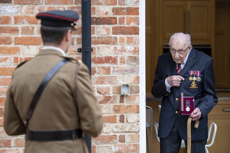 Kapten Tom Moore (kanan) veteran Perang Dunia II dipromosikan menjadi Kolonel Kehormatan di ulang tahunnya yang ke-100 pada 30 April 2020. Ia berhasil menggalang dana lebih dari 30 juta poundsterling (Rp 556 miliar) yang diberikan ke Layanan Nasional Kesehatan Inggris (NHS).