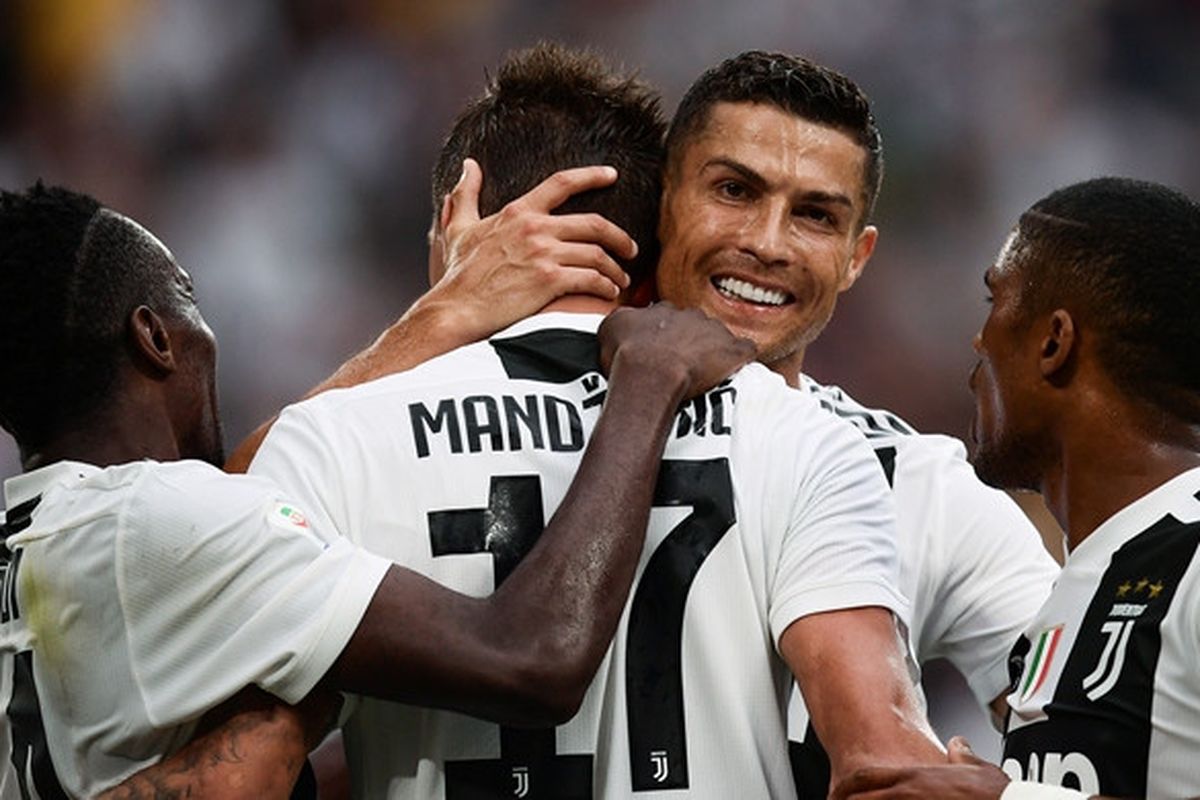 Megabintang Juventus, Cristiano Ronaldo (kedua dari kanan), memeluk Mario Mandzukic yang mencetak gol ke gawang Lazio dalam laga Liga Italia di Allianz Stadium, Turin pada 25 Agustus 2018.
